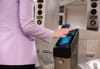 A person taps their smart phone on an OMNY reader to enter the subway system.