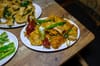 A plate of beef tripe with dried red chilis from Zhego, on a wooden table surrounded by other dishes.
