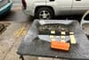A puddle of rainwater on a black table used to play dominos
