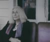 Lucy Sante sits on a porch.