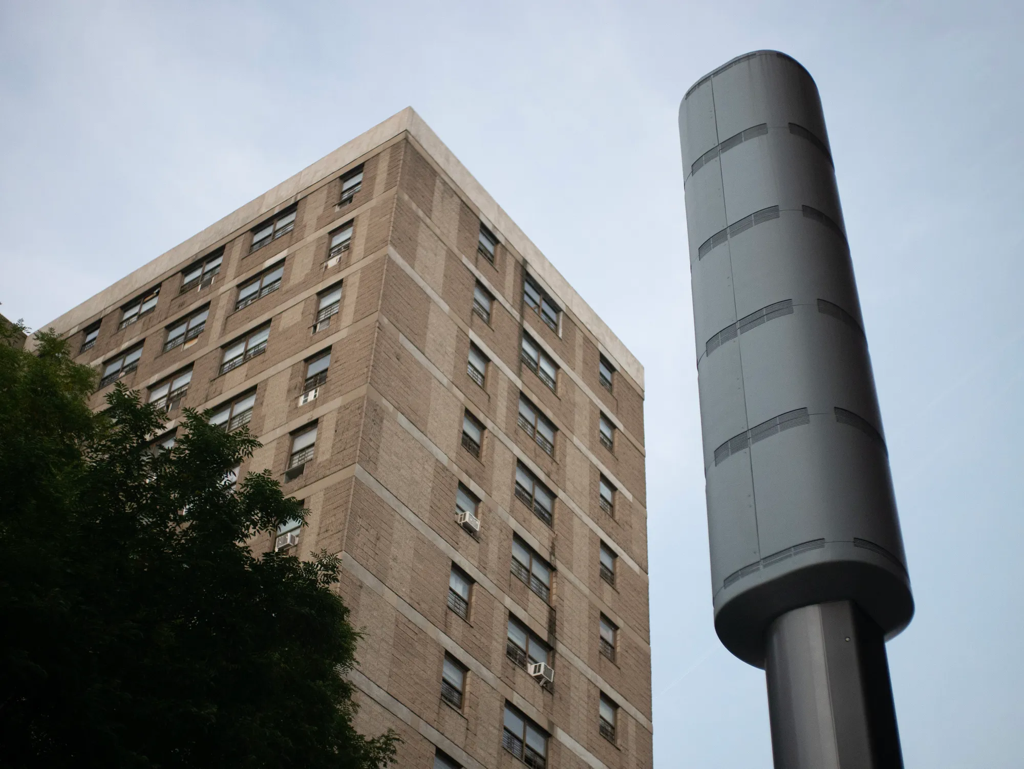 Looking up at a Link5G kiosk with a residential building in the background.